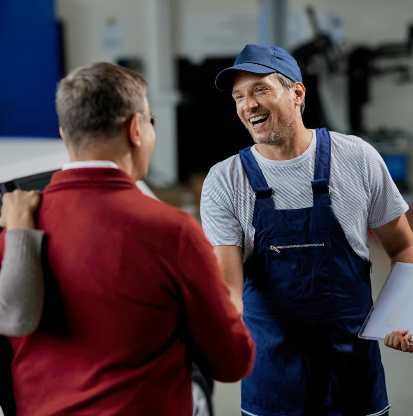 Mechanic and customer shaking hands, representing great service in automotive and plumbing industries.