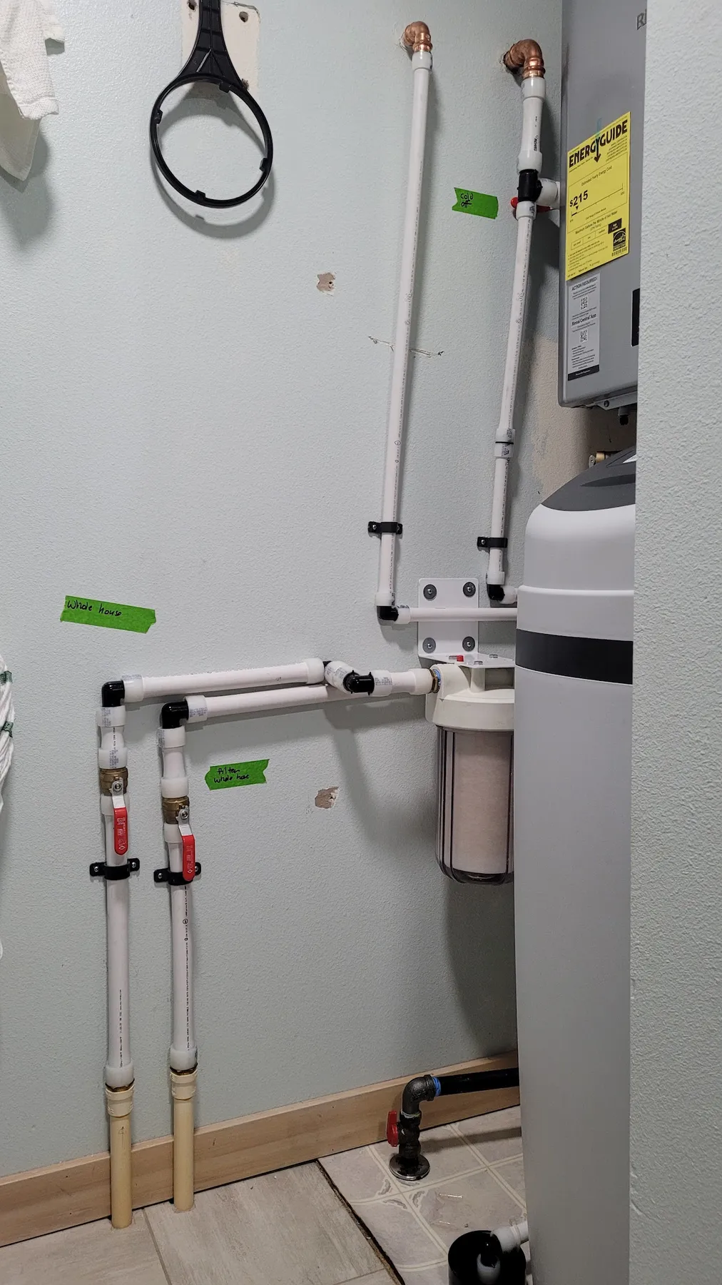 Water softener and filter plumbing run in white PEX with labeled valves