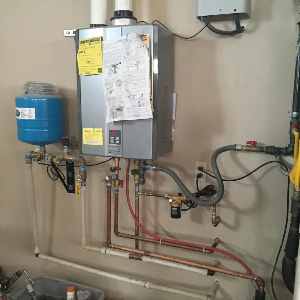 A Rinnai tankless water heater with a blue expansion tank and copper and PEX lines