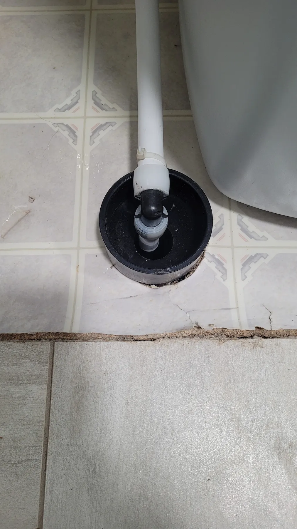 A new toilet flange set clean in a tiled bathroom floor