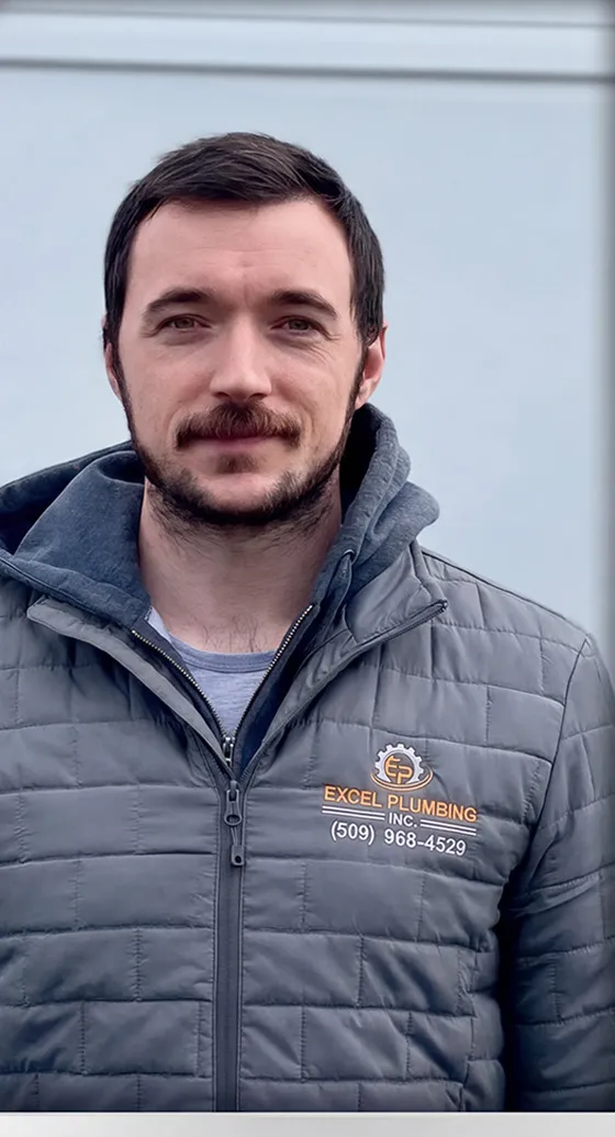 An Excel Plumbing crew member in the gray company jacket