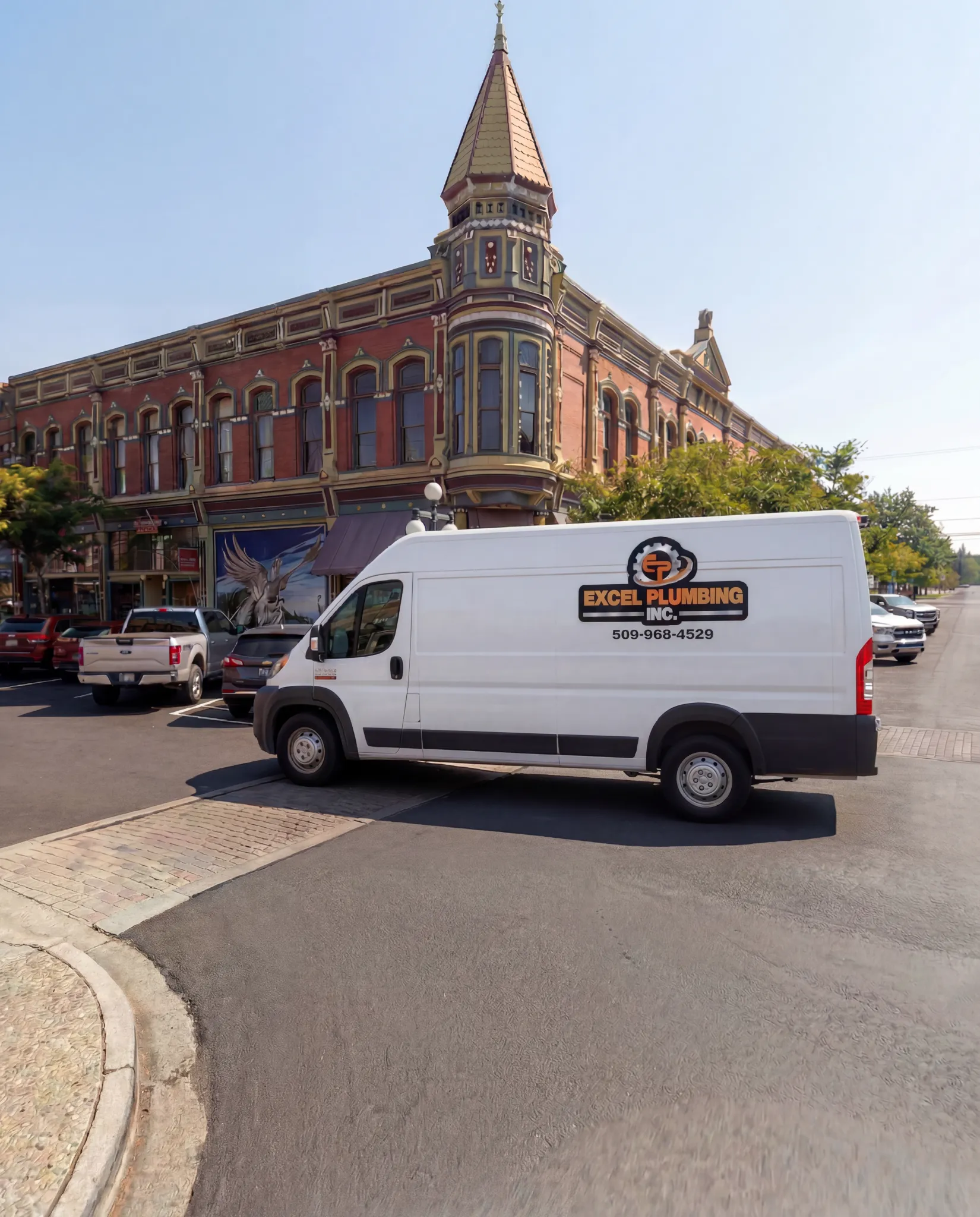 The white Excel Plumbing van parked in front of the Davidson Building in downtown Ellensburg